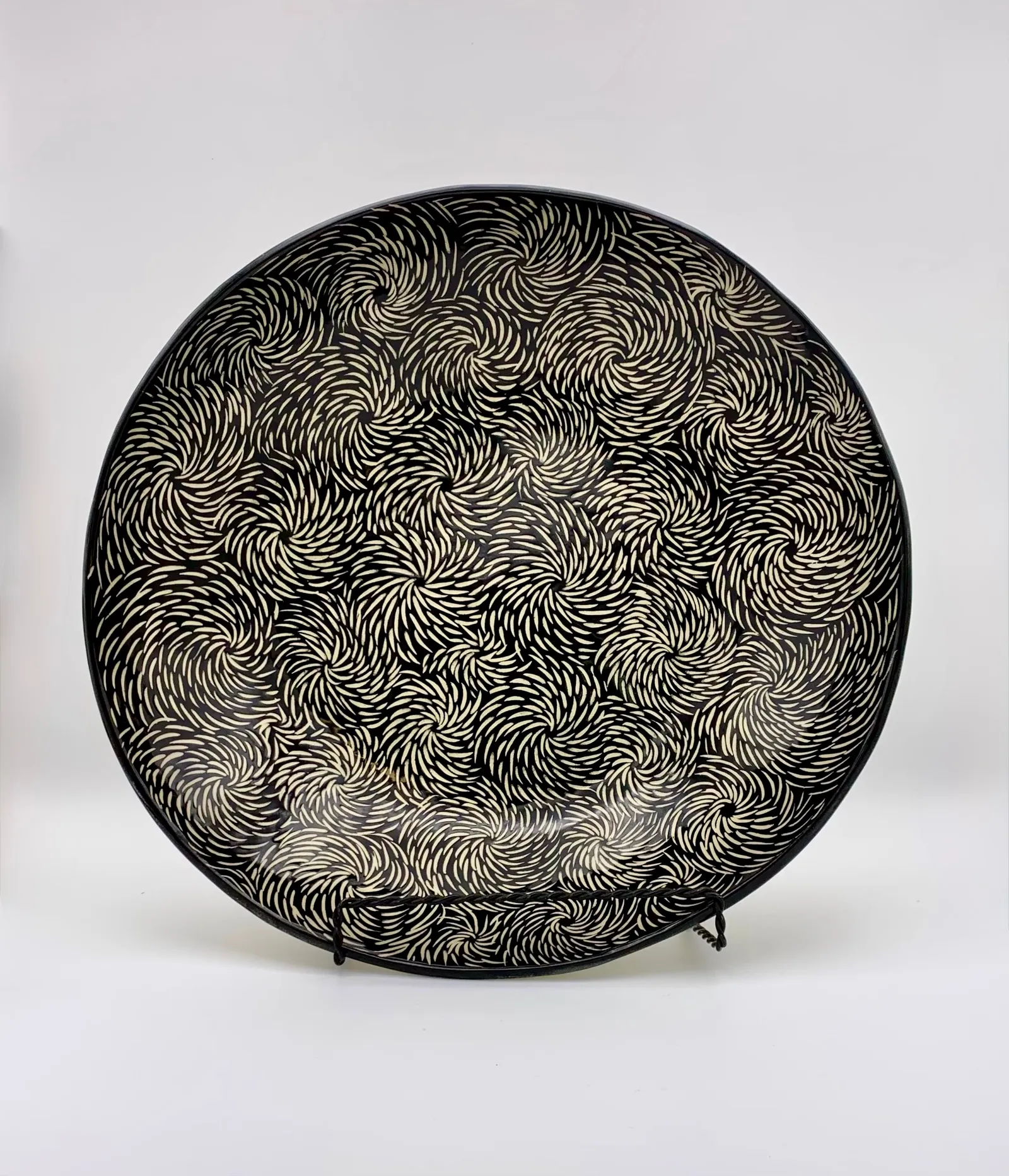 Sgraffito serving dish, 2024, glazed stoneware fired to Cone 6 oxidation, 3 x 12 x 12 in. A black serving dish with white carving in a floral pattern.