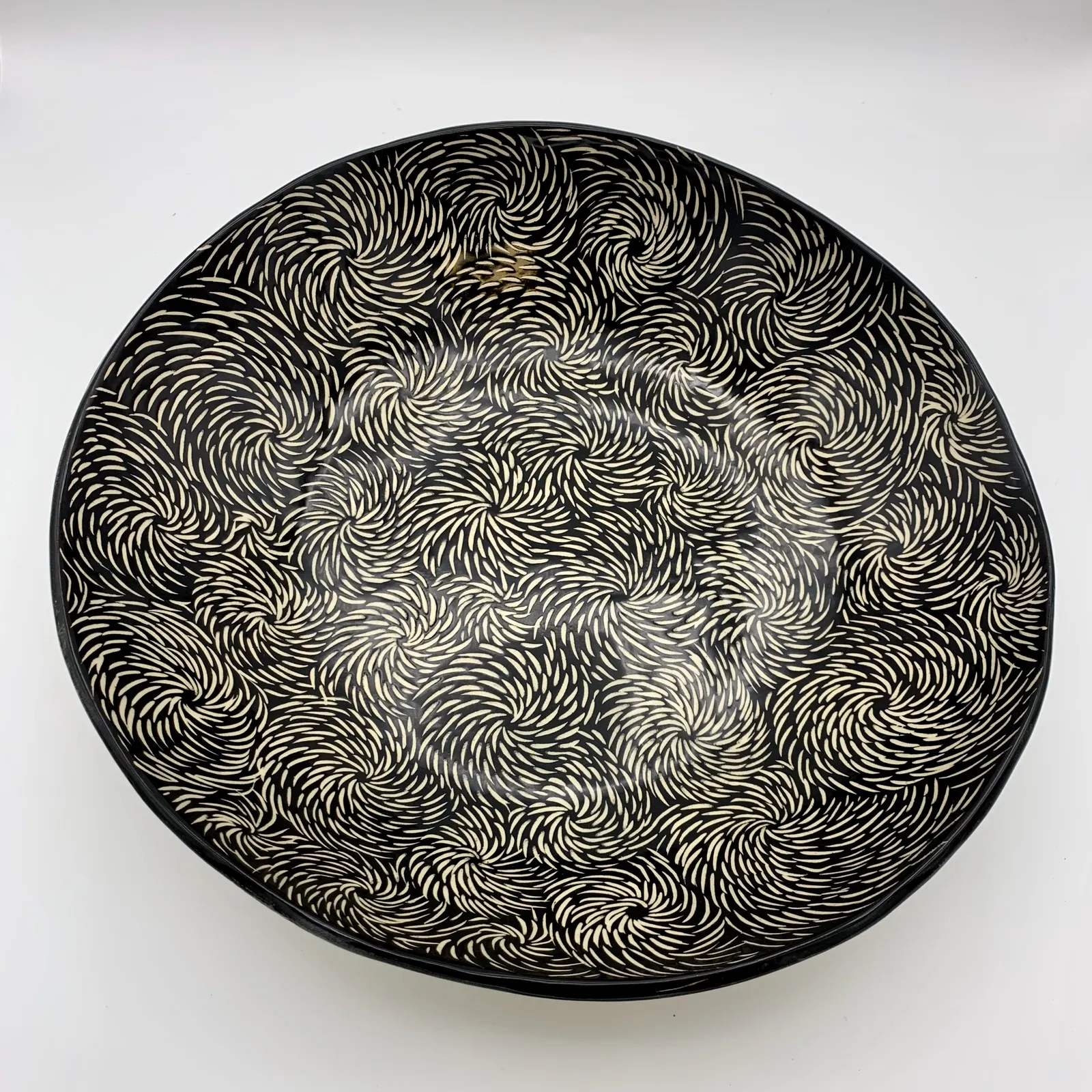 Sgraffito serving dish, 2024, glazed stoneware fired to Cone 6 oxidation, 3 x 12 x 12 in. A black serving dish with white carving in a floral pattern.