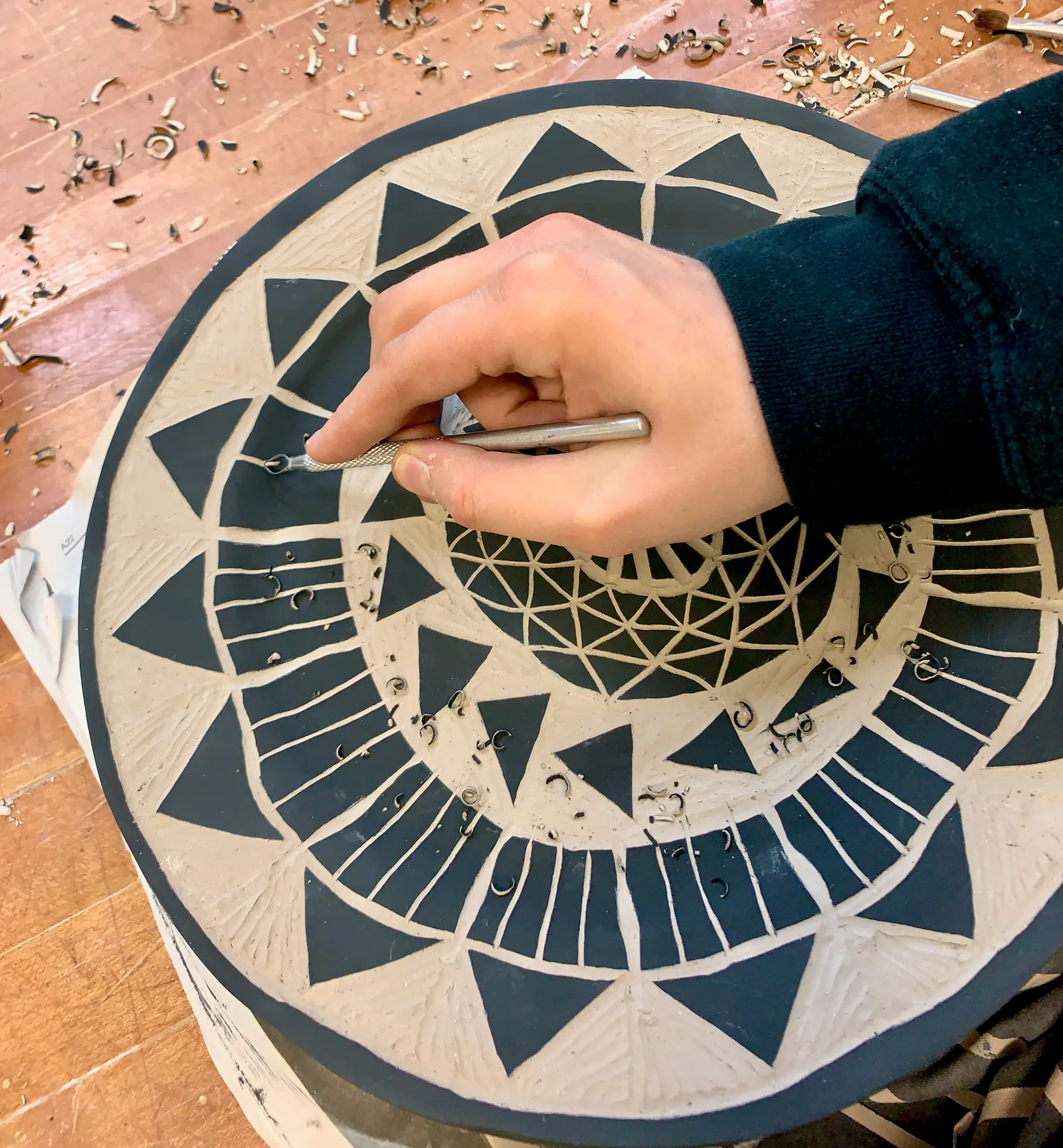 A hand carving a black and white plate