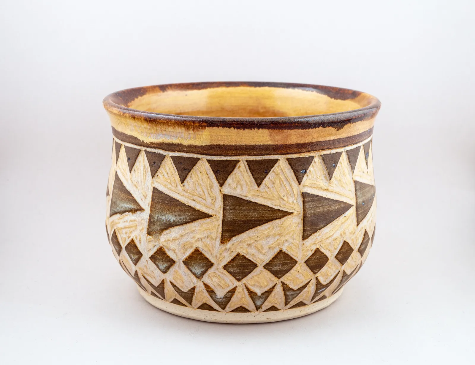 Sgraffito planter, 2019, glazed stoneware fired to Cone 6 oxidation, 4 x 5 x 5 in. A brown and honey-colored planter carved in a geometric pattern.